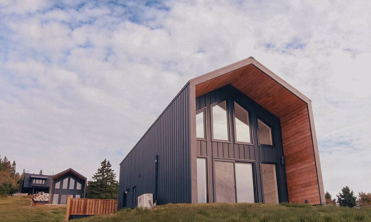 Riverport Cabin | A sanctuary of architectural restraint and unmediated coastal observation, enhanced by illuminated waters.