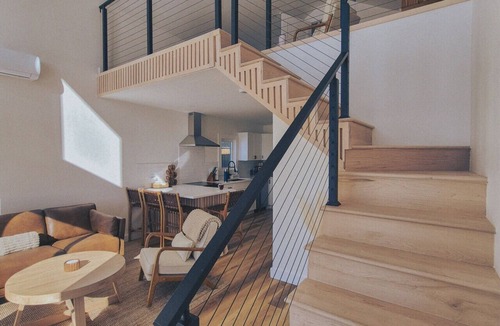 Riverport Cabin | A sanctuary of architectural restraint, unmediated coastal observation, and premium electric travel infrastructure.
