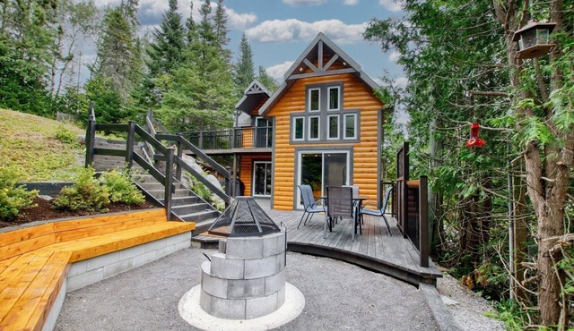 Cottage on the edge of a lake with trail, waterfall and pond