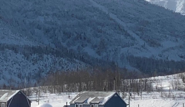 The blue house at the foot of the mountains in Murdochville